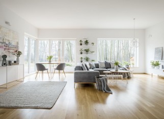 White elegant living room interior with windows, grey corner sofa and modern art posters