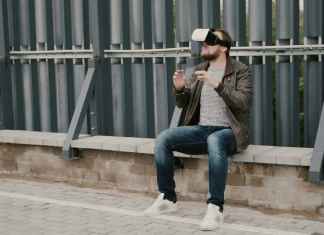 bearded attractive man uses virtual reality glasses on the roof, takes off his glasses and walks away