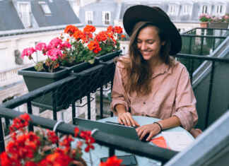 Kobieta na balkonie z kwiatami i osłoną balkonową